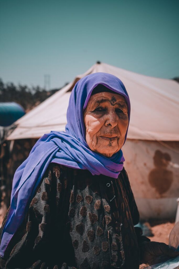 Close-Up Shot of an Elderly Woman in Purple Hijab